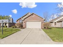 Charming brick home featuring an attached two-car garage and manicured landscaping under a sunny sky at 153 Monticello Ct, Noblesville, IN 46060