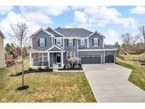 Beautiful two-story home featuring a three-car garage, a well-manicured lawn and beautiful blue paint at 15678 Byrding Dr, Westfield, IN 46074