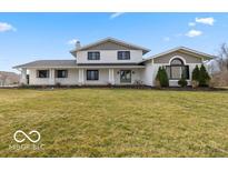 Inviting two-story home boasting a lush green lawn and charming curb appeal with its neutral color palette and covered porch at 19041 Karyn Ln, Westfield, IN 46062
