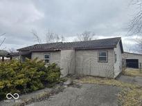 Modest one-story home featuring neutral siding and mature shrubs in an established neighborhood at 2420 N Macedonia Ave, Muncie, IN 47303