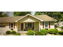 Charming single-story home features red shutters, a cozy porch, and well-maintained landscaping with green bushes at 338 N Darlington St, Jamestown, IN 46147