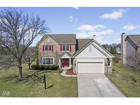 Charming two-story brick home featuring red shutters, attached garage and landscaped front yard at 3644 W 48Th St, Indianapolis, IN 46228
