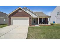 Charming home featuring a brick facade, attached two-car garage, and a cozy front porch at 4150 Viva Ln, Indianapolis, IN 46239