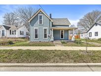 Charming two-story home featuring blue siding, a covered front porch, and well-maintained landscaping at 524 S State St, Greenfield, IN 46140