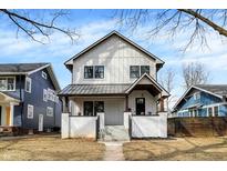 Charming two-story home with white siding, black trim, and inviting front porch at 6034 Guilford Ave, Indianapolis, IN 46220