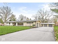 Charming single-story home with stone and white siding, a long driveway, and a three car garage at 671 Spring Hills Dr, Zionsville, IN 46077