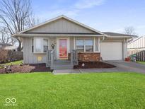 Charming one-story home with well-manicured lawn and inviting red front door at 935 E Mckay Rd, Shelbyville, IN 46176
