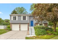 Charming gray split-level home with a blue front door and a two-car garage at 9462 Bent Brook Dr, Indianapolis, IN 46250