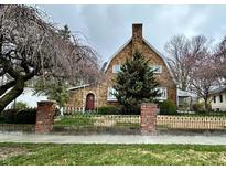 Charming Tudor-style home with a stone facade, a brick chimney, and a well-manicured front yard at 1010 E Harrison St, Martinsville, IN 46151