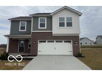Two-story home with gray siding and brick accents, featuring a two-car garage and well-maintained lawn at 2109 Boxwood Dr, Greenfield, IN 46140
