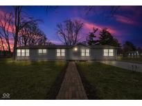 Charming single-story home with a brick walkway leading to the front door, lit up with a twilight sky at 2305 S Rybolt Ave, Indianapolis, IN 46241