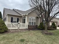 Charming home featuring a white picket fence, brick accents, tidy landscaping, and a well-maintained lawn at 2610 Big Bear Ln, Indianapolis, IN 46217