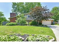 Charming home with a brick chimney and beautiful landscaping, offering curb appeal at 2700 Yellowwood Ct, Columbus, IN 47203