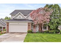 Charming two-story home boasts a manicured lawn, mature trees and an attached two car garage at 3539 Clearwater Cir, Indianapolis, IN 46240