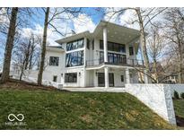 Beautiful modern home with a white exterior, black framed windows, and lush green yard at 395 Breakwater Dr, Fishers, IN 46037