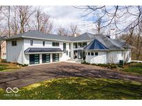 Elegant home featuring a black metal roof, a three-car garage and an extra turret at 395 Breakwater Dr, Fishers, IN 46037