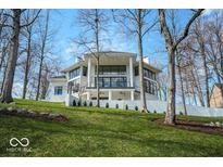 Stunning modern home features large windows, white exterior, and meticulously landscaped grounds at 395 Breakwater Dr, Fishers, IN 46037