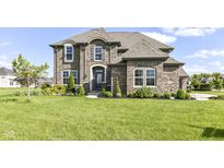 Stunning two-story brick home boasting meticulous landscaping, manicured lawn, and elegant architectural details at 4255 Kettering Dr, Zionsville, IN 46077