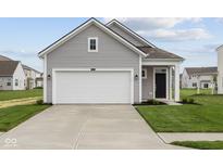 Charming home featuring a two-car garage, manicured lawn, and inviting entrance at 5138 Modernist Blvd, Indianapolis, IN 46237
