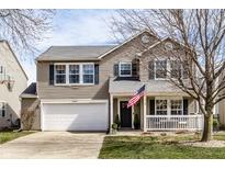 Charming two-story home with a well-manicured lawn and an inviting front porch with American flag at 5687 N Plymouth Ct, McCordsville, IN 46055