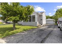 Charming home with a screened-in porch, paved driveway, and a detached garage at 633 Fletcher Ln, Beech Grove, IN 46107