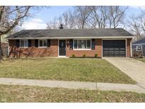 Charming brick ranch-style home with a well-manicured lawn and attached one car garage at 8508 Georgiana Ln, Indianapolis, IN 46226