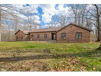Charming brick home with well-maintained lawn and mature trees, under a partly cloudy sky at 8968 Old Haggard Rd, Morgantown, IN 46160