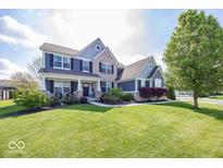 Beautiful two-story home with a manicured lawn, brick, and blue painted siding at 10027 Landis Blvd, Fishers, IN 46040