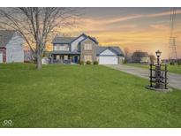 Charming two-story home with a combination of brick and siding and a large green lawn at 10212 Ironway Dr, Indianapolis, IN 46239