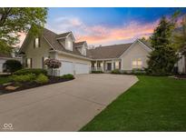 Charming two-story home boasts a three-car garage, beautiful landscaping, and a welcoming front porch at 10725 Grindstone Dr, Fishers, IN 46037