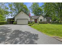 Charming single-story home boasts a two-car garage, an inviting front yard, and tasteful landscaping at 10757 Kelly Ct, Indianapolis, IN 46231