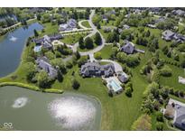 Stunning aerial view of an estate home, showcasing a pool, pond, and lush green landscaping at 1098 Laurelwood, Carmel, IN 46032
