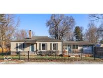 Charming single-story home featuring a cozy design and a well-maintained front yard with mature trees at 1702 E 58Th St, Indianapolis, IN 46220