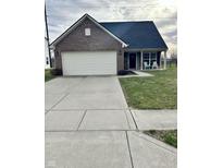 Charming brick home featuring an attached two-car garage, well-manicured lawn, and inviting front porch with seating at 1905 Collingwood Dr, Avon, IN 46123