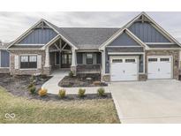 Charming craftsman style home with brick and siding, featuring a three-car garage and professionally landscaped yard at 2145 W Bedrock Ln, Greenfield, IN 46140