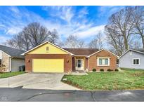 Charming brick home with a bright yellow garage door and a well-manicured front lawn at 2618 Inlet Dr, Cicero, IN 46034