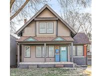 Charming two-story home featuring a covered front porch and a bright turquoise-colored front door at 3335 Central Ave, Indianapolis, IN 46205