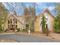 Beautiful home with stone and siding exterior, a red front door, and mature landscaping at 3849 Waycross Dr, Columbus, IN 47203