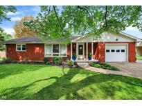Charming red brick ranch-style home with attached garage, manicured lawn, and well-maintained landscaping at 4146 Roselawn Ave, Columbus, IN 47203