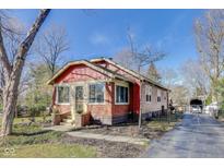 Charming exterior view of a red brick and wood home, showcasing its cozy curb appeal and fenced yard at 5330 Manker St, Indianapolis, IN 46227