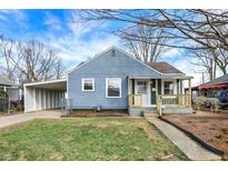 Charming blue home featuring a covered carport and a cozy front porch area at 5350 E 20Th Pl, Indianapolis, IN 46218