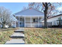 Charming single story home featuring a covered front porch and walkway on a sunny day at 553 N Traub Ave, Indianapolis, IN 46222