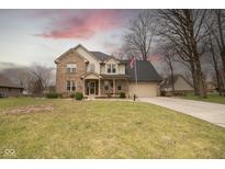 Charming two-story brick home with a well-manicured lawn and attached two-car garage at 63 Park Forest N Dr, Whiteland, IN 46184
