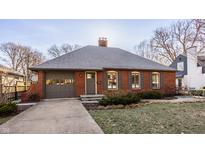 Charming red brick home with gray shutters, attached garage and well maintained lawn at 7021 Warwick Rd, Indianapolis, IN 46220