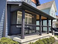 Inviting front porch features a seating area, modern railings, dark wood trim, and a wood ceiling at 1334 E Market St, Indianapolis, IN 46202
