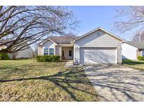Charming single-story home with a well-maintained lawn, attached garage, and beautiful curb appeal on a sunny day at 1360 Evergreen Dr, Greenfield, IN 46140