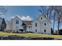 Charming two-story white home featuring an inviting front yard landscape and architectural details at 14402 Allison Dr, Carmel, IN 46033