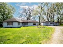 Charming single-story home with a spacious front lawn and detached two-car garage at 1821 E Stop 10 Rd, Indianapolis, IN 46227