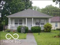 Charming single-story home features a cozy front porch, well-maintained lawn, and classic architectural details at 1835 Carpenter Cir, Indianapolis, IN 46203