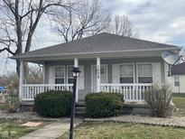 Charming home featuring a cozy front porch, gray siding, and a well-maintained landscaped yard at 1835 Carpenter Cir, Indianapolis, IN 46203